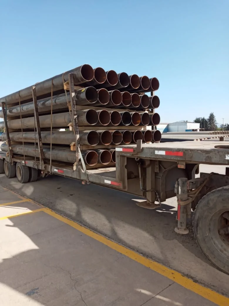 Camión transportando tuberías metálicas para proyectos hidráulicos